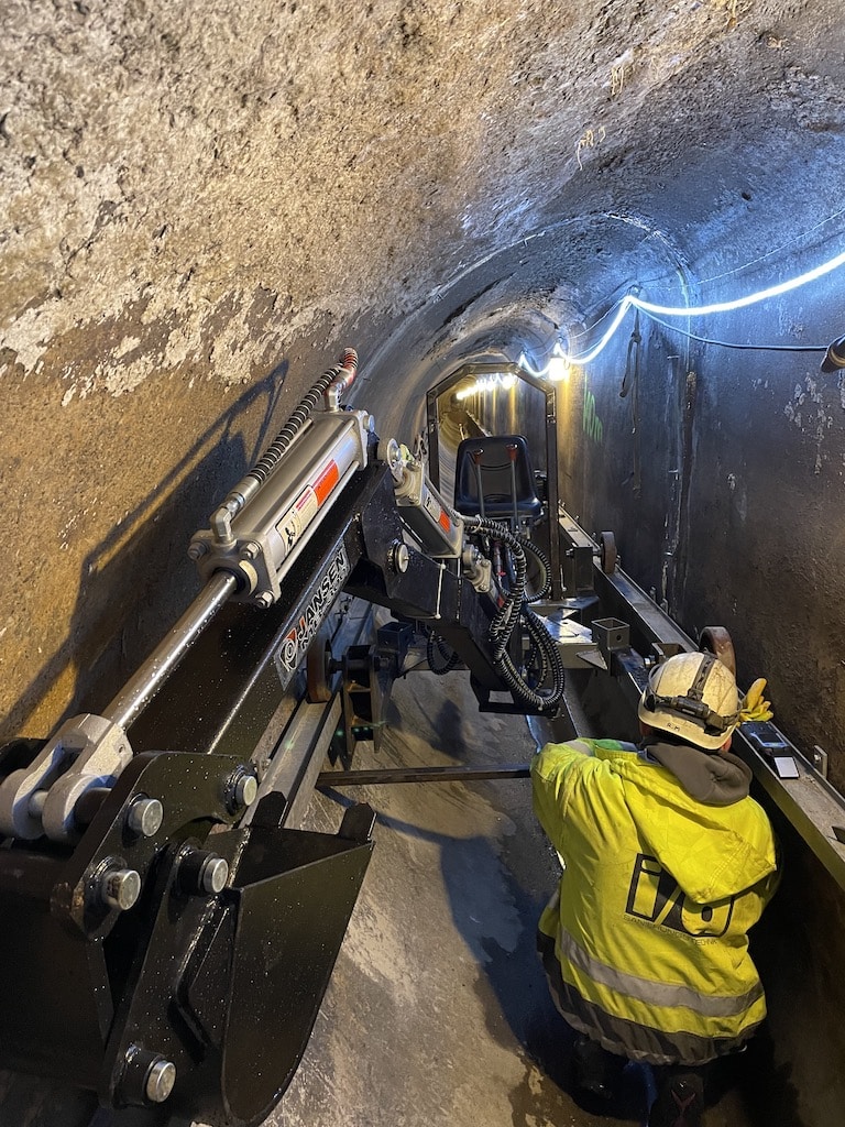 Der Rheindüker wird jetzt mit einem elektrisch betriebenen Minibagger gereinigt, der auf Stahlträgern als Schienen im Kanal fährt und so die Ablagerungen ausbaggert,(c)Stadtentwässerungsbetrieb der Landeshauptstadt Düsseldorf Der Rheindüker wird jetzt mit einem elektrisch betriebenen Minibagger gereinigt, der auf Stahlträgern als Schienen im Kanal fährt und so die Ablagerungen ausbaggert,(c)Stadtentwässerungsbetrieb der Landeshauptstadt Düsseldorf