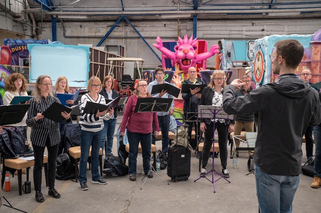 Kammerchor singt neben Jacques Tillys Karnevalswagen
