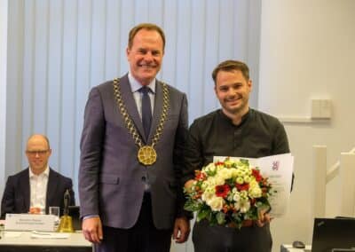 Benjamin Tscholl. Oberbürgermeister Dr. Stephan Keller verleiht am 27.8.2024 in der Sitzung der BV5 Ehrennadeln. Foto: Landeshauptstadt Düsseldorf / Uwe Schaffmeister