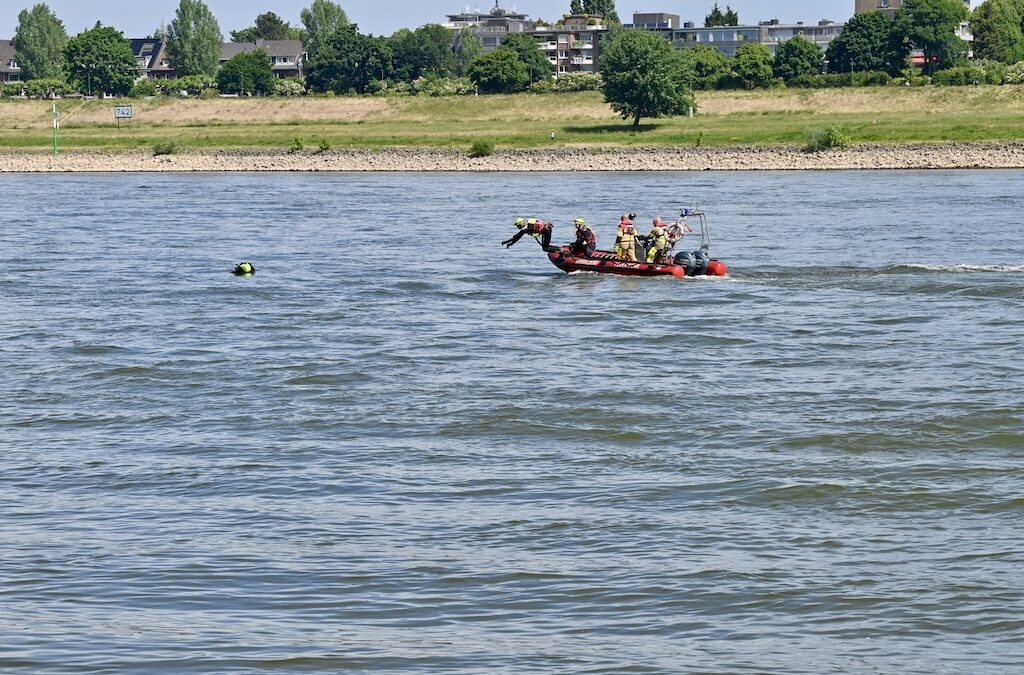 „Rettungstaucher demonstrieren die Rettung einer Person, die im Rhein treibt.“