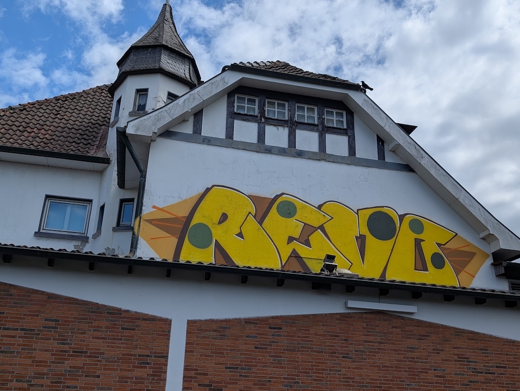 Ein gelbes Graffiti ziert die Seitenwand von Haus Litzbrück © Gabriele Schreckenberg
