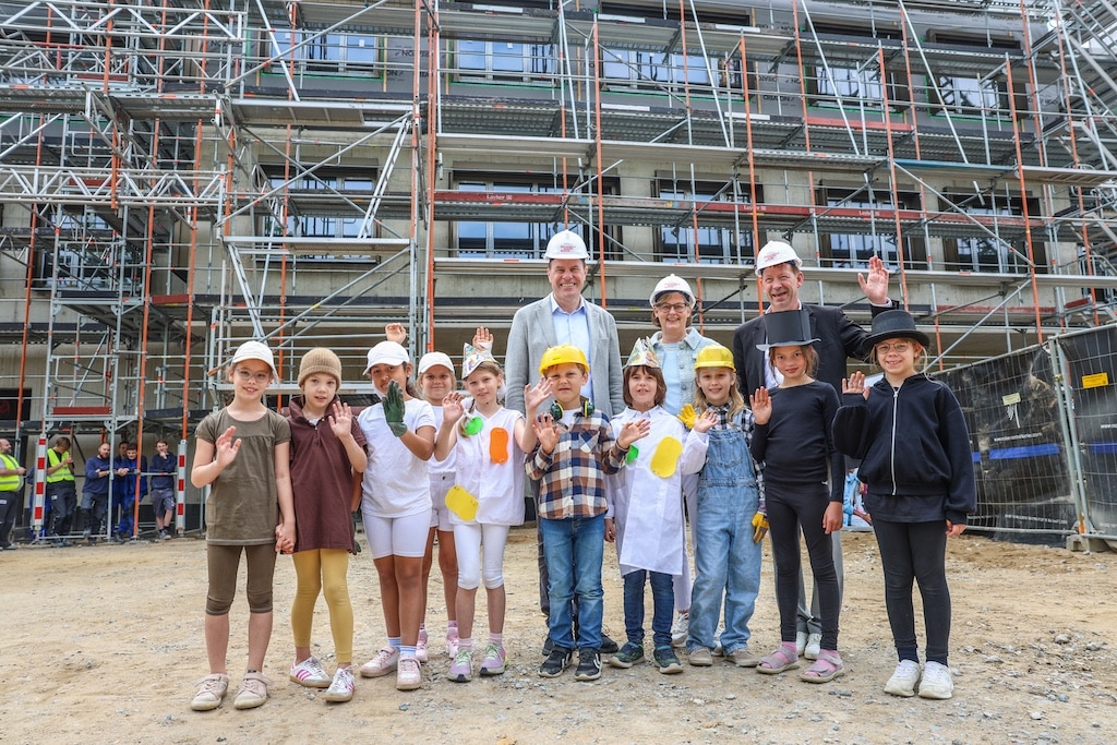 Beim Richtfest (v.l.): Oberbürgermeister Dr. Stephan Keller, komm. Schulleiterin Susanne Schulz-Isenbeck und Stadtdirektor Burkhard Hintzsche mit Schülerinnen und Schülern der 2a. © Landeshauptstadt Düsseldorf/Melanie Zanin