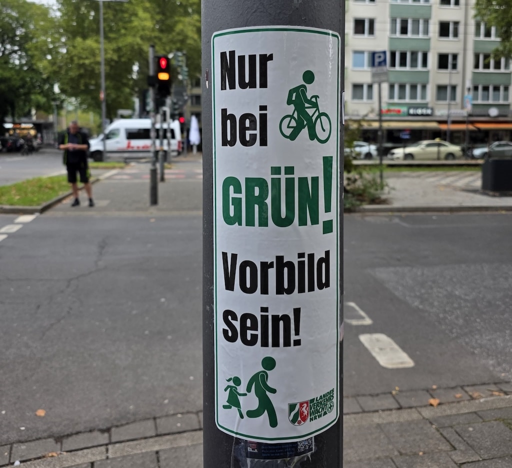 Mit einem neuen Aufkleber auf Ampelmasten "Nur bei Grün! – Vorbild sein!" der Landesverkehrswacht NRW sollen Zufußgehende im Straßenverkehr daran erinnert werden, Ampelanlagen grundsätzlich nur bei Grün zu überqueren. 50 Aufkleber wurden jetzt in Abstimmung mit der Landeshauptstadt an Ampelmasten angebracht. © Verkehrswacht Düsseldorf e. V.