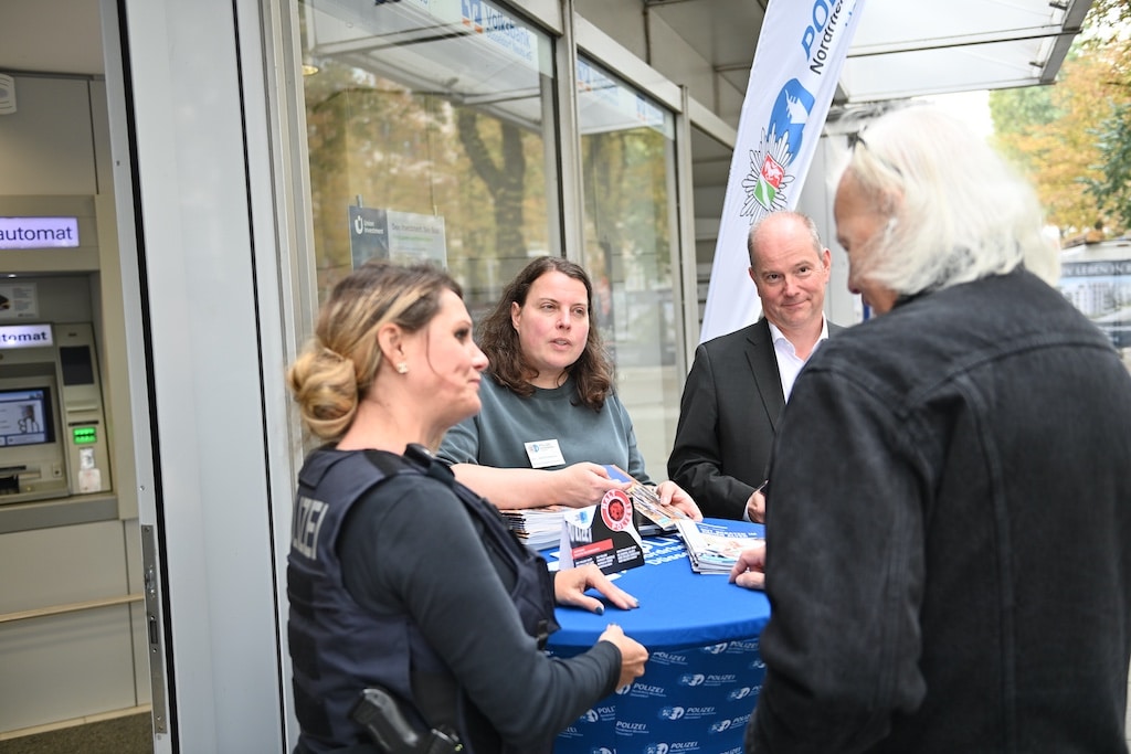 Polizistin Birgit SchwertfechterNadine Kolczeweski und Andreas Picker von der Volksbank beraten einen älteren Kunden © Lokalbüro