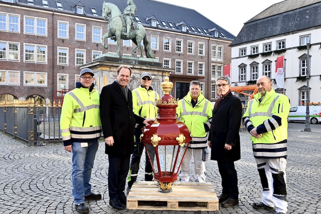 Oberbürgermeister Dr. Stephan Keller (2.v.l) und Torben Beisch, Geschäftsführer der Netzgesellschaft (2.v.r) präsentieren mit Mitarbeitern der Netzgesellschaft die frisch restaurierten Köpfe der Leuchten. © Lokalbüro