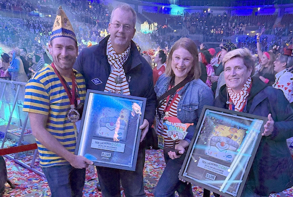 Eine gegenseitige Übergabe: Maximilian Arntz (l.) und Claudia Daufenbach (2.v.r) von D.Live überreichen Michael Burgmer und Nasthalie Drmota ein Poster. Diese wiederum kontern mit einem Standlogo. Das sei nicht abgesprochen gewesen, betonen alle vier lachend. © LB / Manfred Fammler