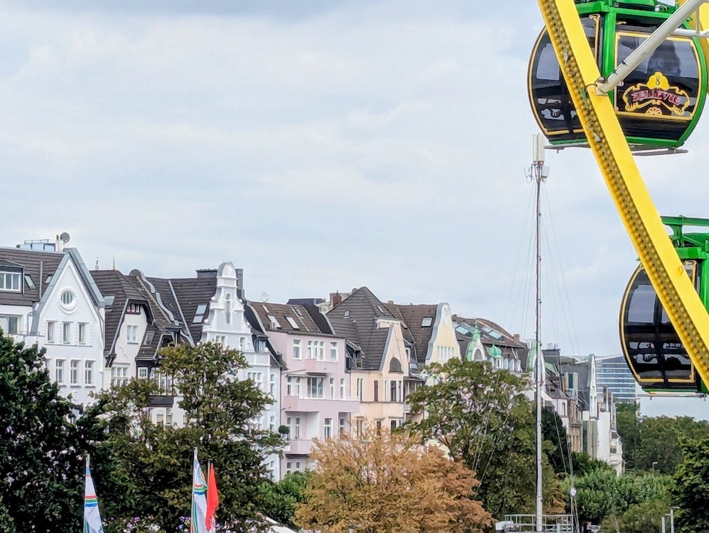 Das Institut für Denkmalschutz und Denkmalpflege hat diese saisonale Stadtansicht Rheinkirmes und Ortsbild Oberkassel zum Anlass genommen, den Denkmalbereich Oberkassel als Düsseldorfs Denkmal des Monats Juli 2026 vorzustellen. © Landeshauptstadt Düsseldorf/Institut für Denkmalschutz und Denkmalpflege
